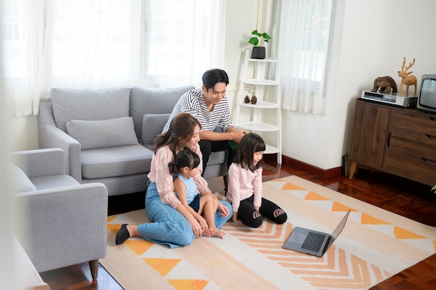 Asian family with children using laptop computer at home