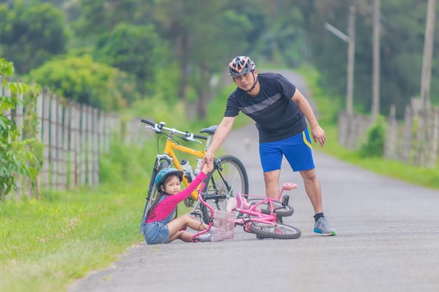 Asian father and daughter Riding bicycles on the street.