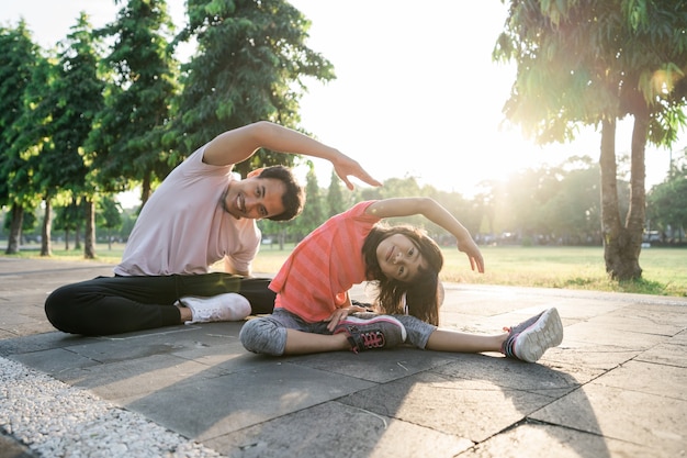 Asian father and little daughter do exercises in outdoor