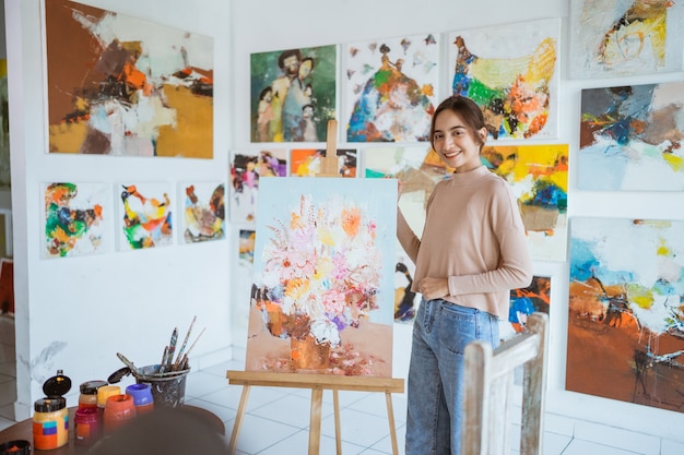 Asian female artist painting on canvas doing some art projects on her studio workshop