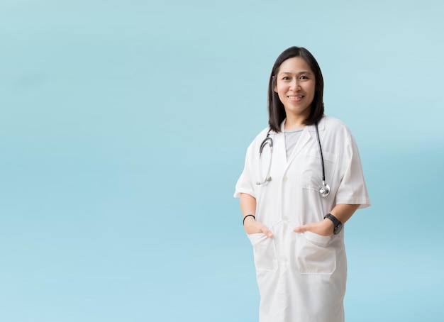 Asian female doctor posing and smiling isolated on blue background with Clipping paths for design work empty free space