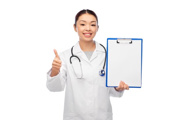 Photo asian female doctor with clipboard shows thumbs up