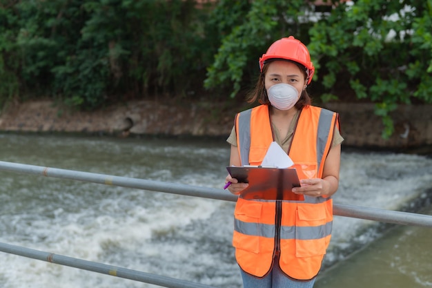 Asian Female engineering working xA at sewage treatment plantMarine biologist analysing water test resultsWorld environment day concept