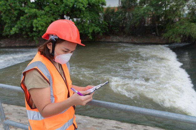 Asian Female engineering working xA at sewage treatment plantMarine biologist analysing water test resultsWorld environment day concept