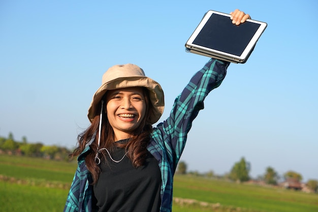 Asian female farmer delighted with rice growth target Computer analysis