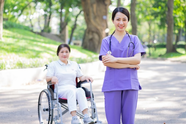 Asian female nurse taking care of a middleaged female patient in the park