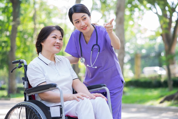 Asian female nurse taking care of a middleaged female patient in the park