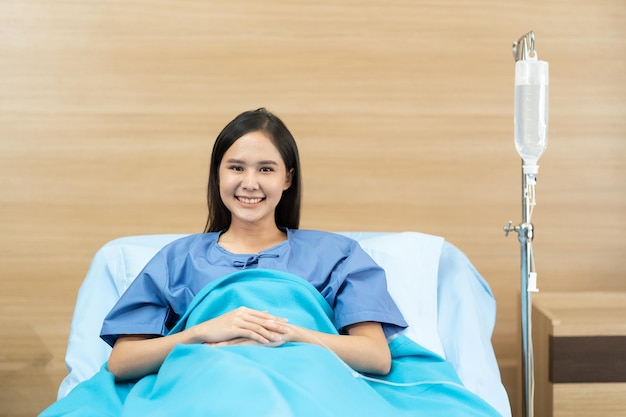 Asian female patient with happiness lying on bed in hospital