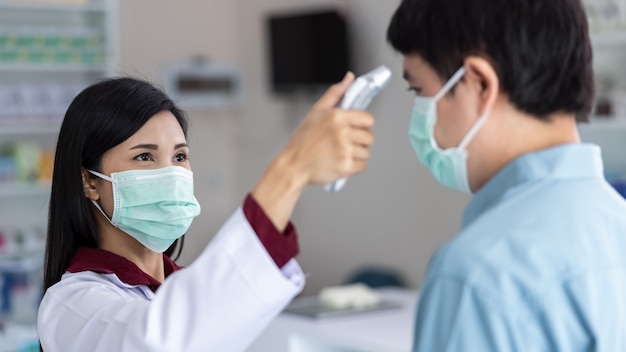 Asian Female pharmacists measure the fever before visiting the drugstore