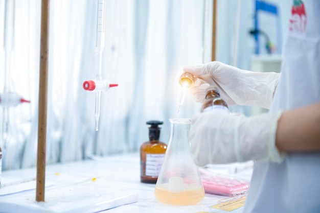 Asian female specialist in quality control lab examining tomato ingredient food in research lab food industry