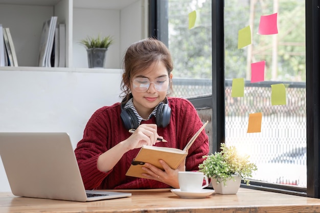 Asian female student study online in class study online wearing headphones watching video call zooming happy asian female learning language online with computer laptop