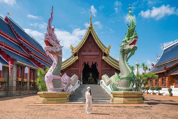 Asian female tourist come to worship at Wat Ban Den or Wat Den Salee Sri Muang Gan the Lanna style temple and colorful statue sculpture at Chiang Mai