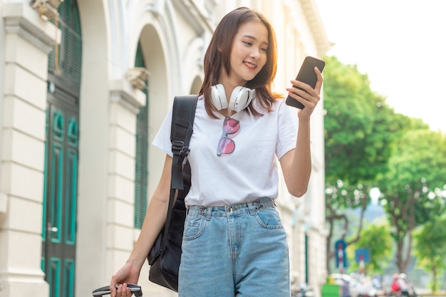 Asian female tourist is using her phone to find her way