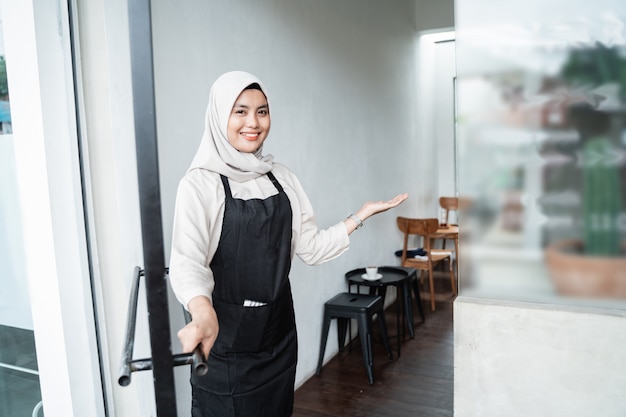 Asian female waiter invite guests to enter