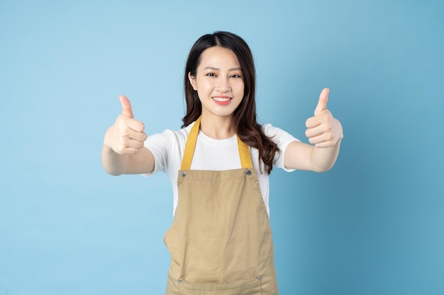 Asian female waitress portrait, isolated on blue background