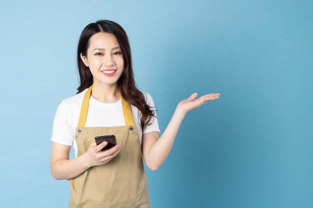 Asian female waitress portrait, isolated on blue background