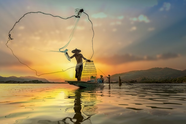 Asian Fishermen on boat fishing at lake