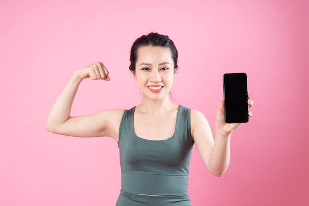 Asian fitness girl portrait, isolated on pink background