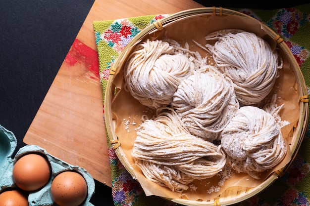 Asian food concept fresh homemade organic Alkaline noodles on wooden board with black background with copy space