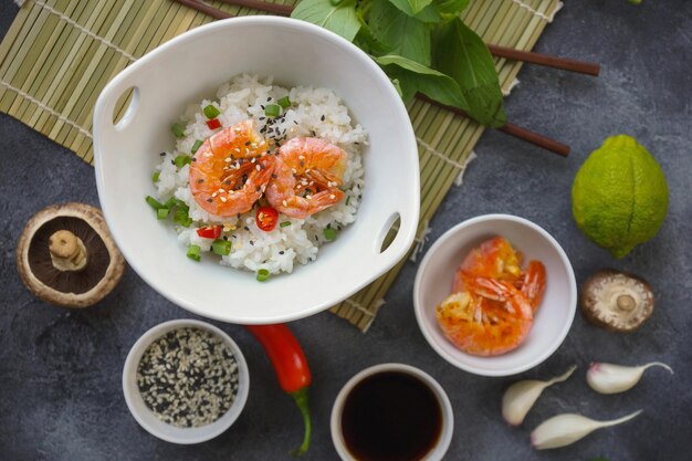 Asian food on a dark background, During preparation, Wok rice with shrimps and mushrooms