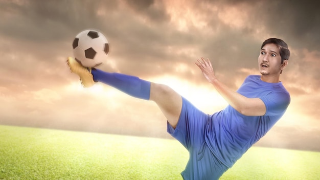 Asian football player man in a blue jersey kicking the ball