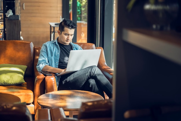 Asian freelancer in blazer with laptop in cafe near window Profession is blogger freelance translator and writer Freelance translator works in coffee shop online learning