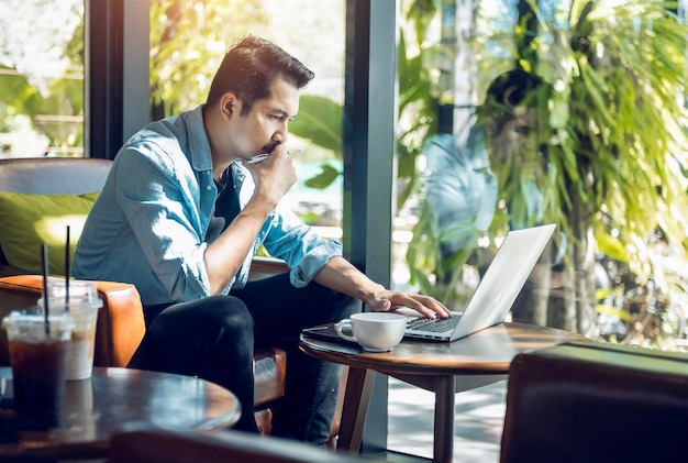 Asian freelancer in blazer with laptop in cafe near window Profession is blogger freelance translator and writer Freelance translator works in coffee shop online learning