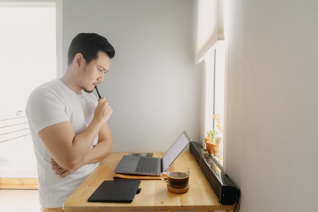 Asian freelancer man is thinking and working on his laptop