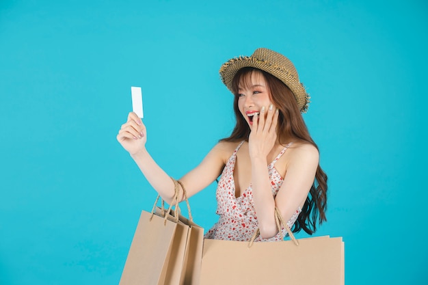 Asian girl carrying shopping bags with summer dress and enjoys shopping