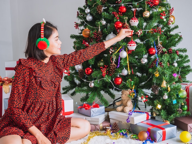 Asian girl celebrating Christmas in house,woman decorate the Christmas tree 