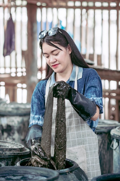 Asian girl Dyeing fabric With natural indigo from Sakon Nakhon