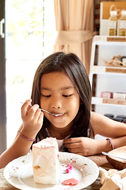 Asian girl eatting cake in cafe.