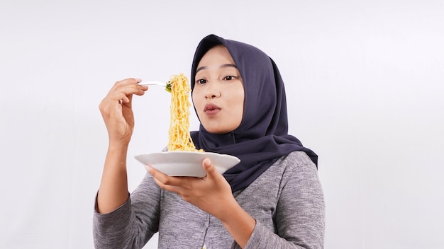 Asian girl happily enjoying noodles isolated on white background