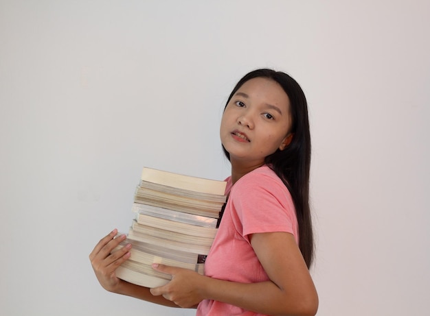 Asian girl hold book on her arm on whiye backgroundStudent girl