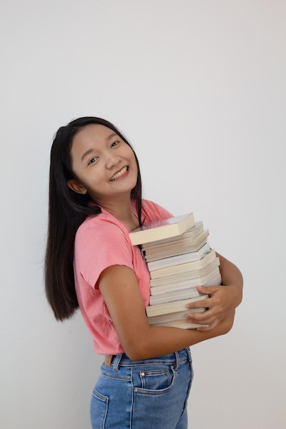 Asian girl hold book on her arm on whiye backgroundStudent girl