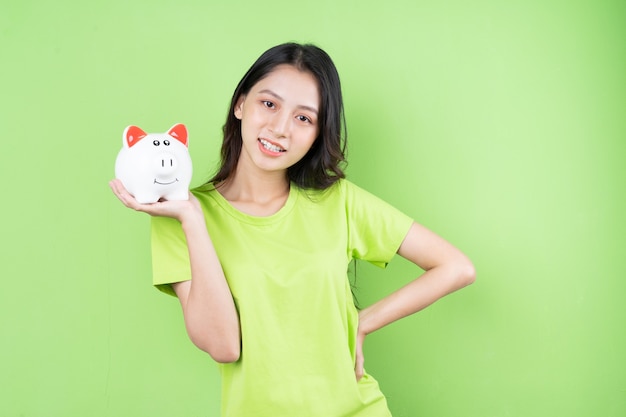 Asian girl holding piggy bank in her hand money saving concept