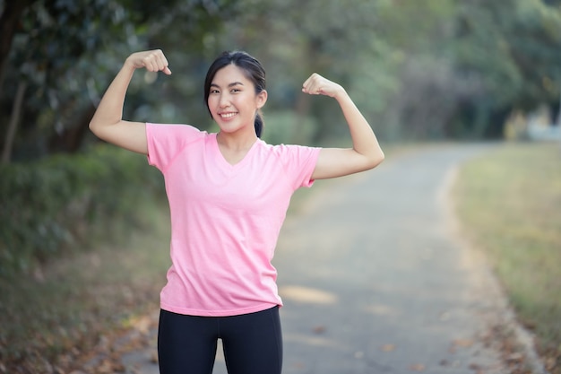 Asian girl is stretching her body warm muscles before going out for a run at the park