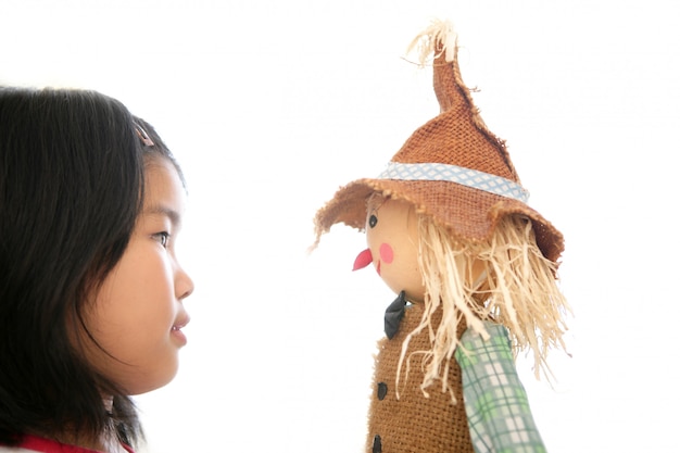 Asian girl looking her scarecrow toy