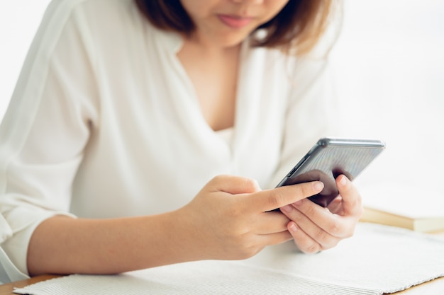 Asian girl Play smartphone For entertainment and work outside the office 