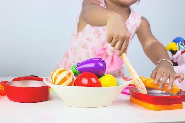 Asian girl playing toy cooking