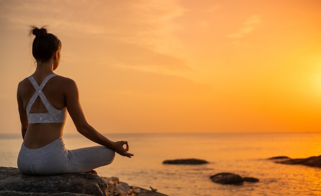 Asian girl practice Yoga on the beach Sunrise morning day