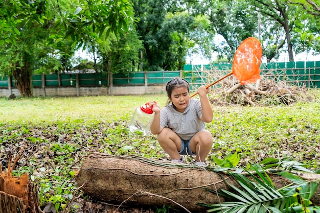 An Asian girl protrait she is adventuring in a wide world Along with a bug catcher She was scared of an unknown insect animal