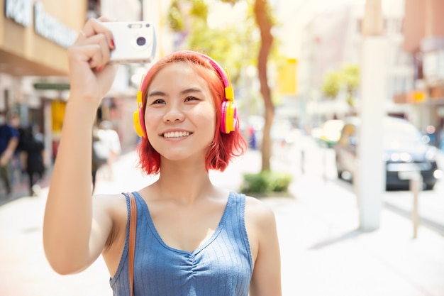 Asian girl teen happy smile to travel with camera take a photo around the city outdoor summer season