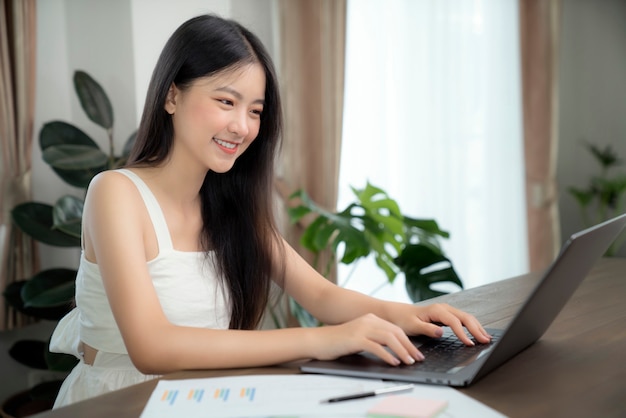 Asian girl typing data to her computer notebook for prepare her report