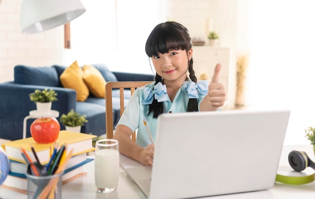 Asian girl using Laptop computer for online study homeschooling during home