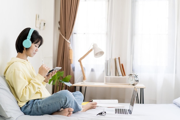 Asian girl using tablet computer in bed room