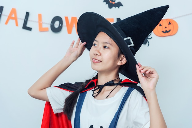 Asian girl witch costume playing in the room Happy Halloween 