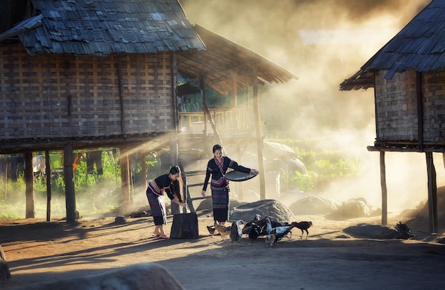 Asian girls feeding chickens at Laos countryside