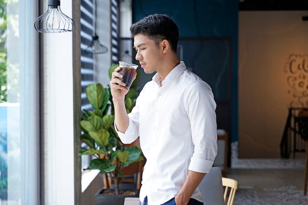 Asian handsome businessman or office worker or young student drinking coffee at cafe shop