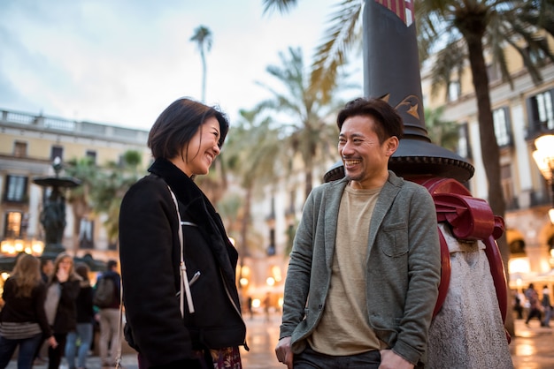 Asian happy tourist couple talking in a square